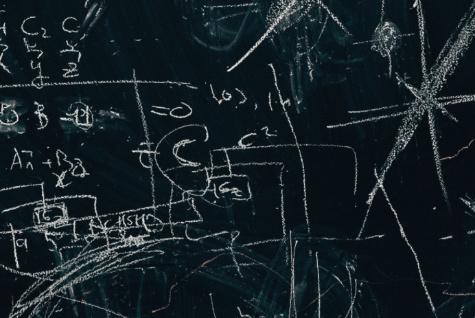 Math formulas written with white chalk on blackboard