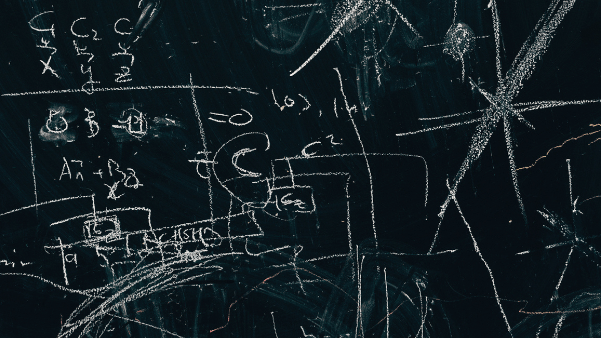 Math formulas written with white chalk on blackboard