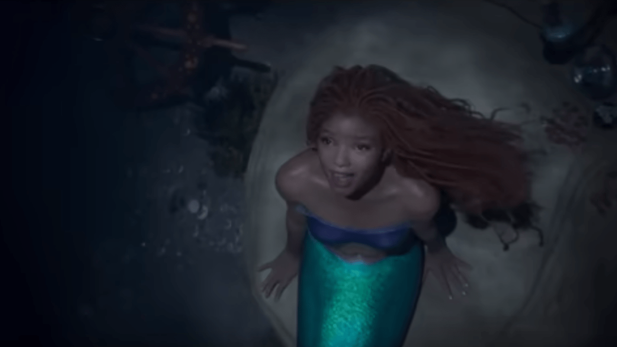 Halle Bailey with long, reddish-brown locs in a mermaid costume as Ariel in Disney's Live-Action Remake of The Little Mermaid