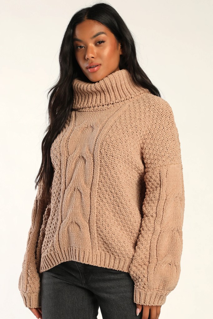 Lighter-skinned Black girl with long, straight hair wearing a beige, chunky, cable-knit, cozy fall sweater