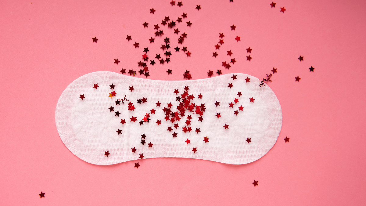 period pad on pink background with red stars symbolizing menstruation