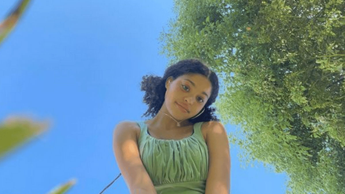 symera jackson with hair in two low puffs gazing at camera outside