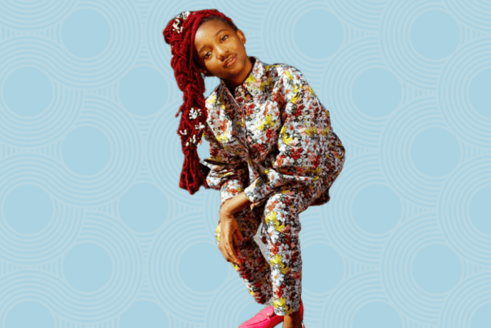 Aria Brooks on blue background leaning forward in a pose