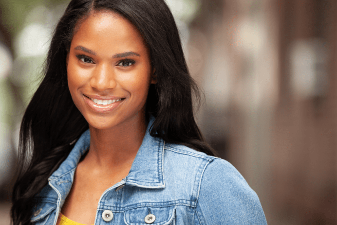 Journee Brown headshot; long, dark brown hair, wearing yellow shirt and light wash blue denim jacket