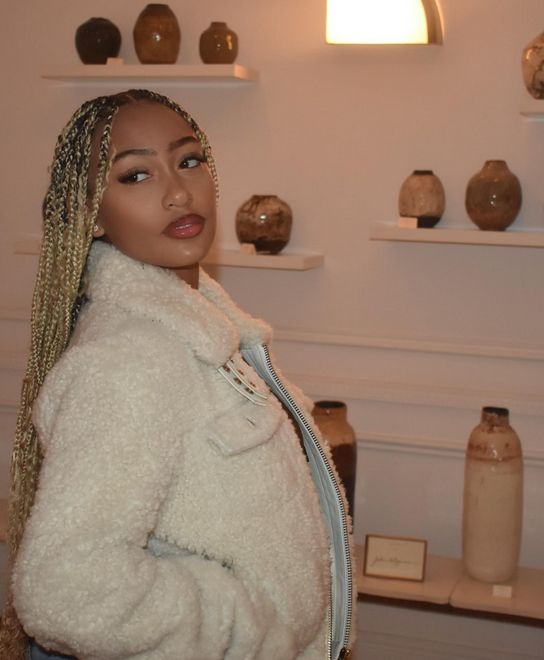 Lexi Underwood wears long, blonde braids with a soft glam look -- light foundation, light blush, eye liner, mascara, and the lip liner/lip gloss combo.